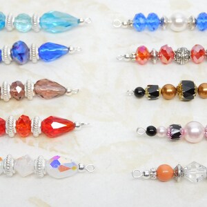 May include: A collection of ten beaded jewelry components, each featuring a unique arrangement of colorful beads. The beads include various shapes and colors, such as blue, red, brown, and iridescent, with silver-toned metal accents.