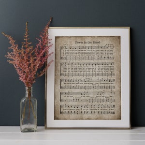 May include: A vintage sheet music print with the title "Power in the Blood" and lyrics. The print is on aged paper with a brown background and black text. The sheet music includes musical notes and a treble clef.