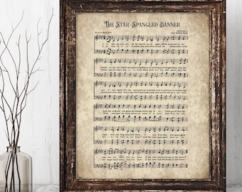 Puede incluir: Una impresión enmarcada de la partitura de "The Star-Spangled Banner" en un marco de madera marrón oscuro. La partitura tiene un aspecto vintage envejecido con notas musicales y letras.