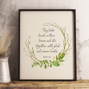 Puede incluir: Un diseño de arte de pared imprimible con una corona de hojas verdes y el texto "Rompieron el pan en sus hogares y comieron juntos con corazones alegres y sinceros. HECHOS 2:46"