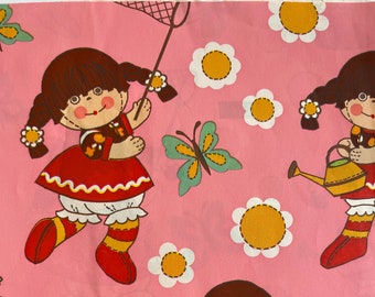 Könnte beinhalten: Rosafarbener Stoff mit einem sich wiederholenden Muster aus drei Puppen mit braunen Haaren und roten Kleidern, Schmetterlingen, Vögeln und gelben Blumen. Die Puppen halten ein Schmetterlingsnetz, eine Gießkanne und eine Blume.
