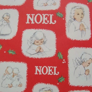 May include: Red wrapping paper with a repeating pattern of white angels with wings, praying with hands clasped. The paper also has the word "NOEL" printed in white.