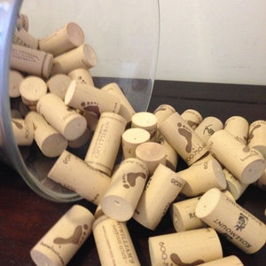 May include: A glass jar filled with a variety of wine corks. The corks are made of natural cork and have different labels and logos, including "MPWILLIAMS", "MARWOOD ESTATE", "ROSEMOUNT", and "600-750".