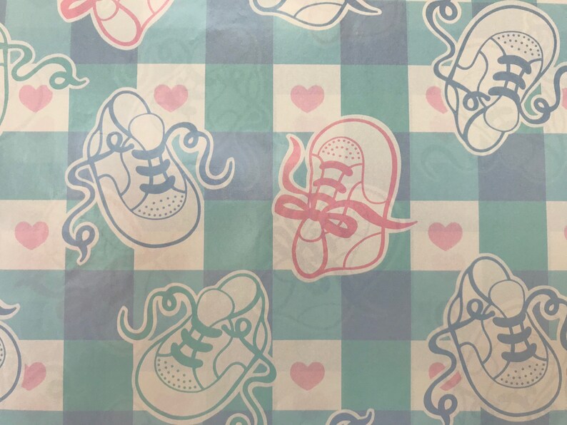 May include: A blue and white checkered pattern with a repeated design of white baby shoes with pink and blue laces. The background is a light blue and white checkered pattern with pink hearts.