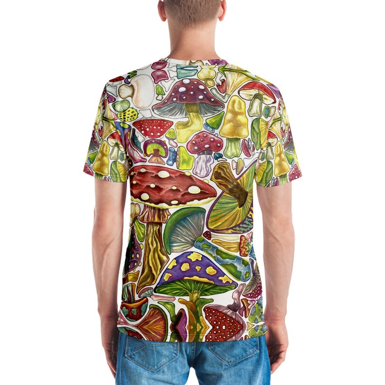 K&ouml;nnte beinhalten: Ein wei&szlig;es T-Shirt mit einem bunten Allover-Druck aus verschiedenen Pilzen in unterschiedlichen Formen, Gr&ouml;&szlig;en und Farben.