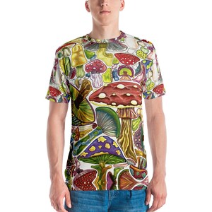K&ouml;nnte beinhalten: Ein wei&szlig;es T-Shirt mit einem bunten Allover-Druck aus verschiedenen Pilzen. Die Pilze sind in verschiedenen Formen, Gr&ouml;&szlig;en und Farben, darunter Rot, Gelb, Gr&uuml;n und Lila.