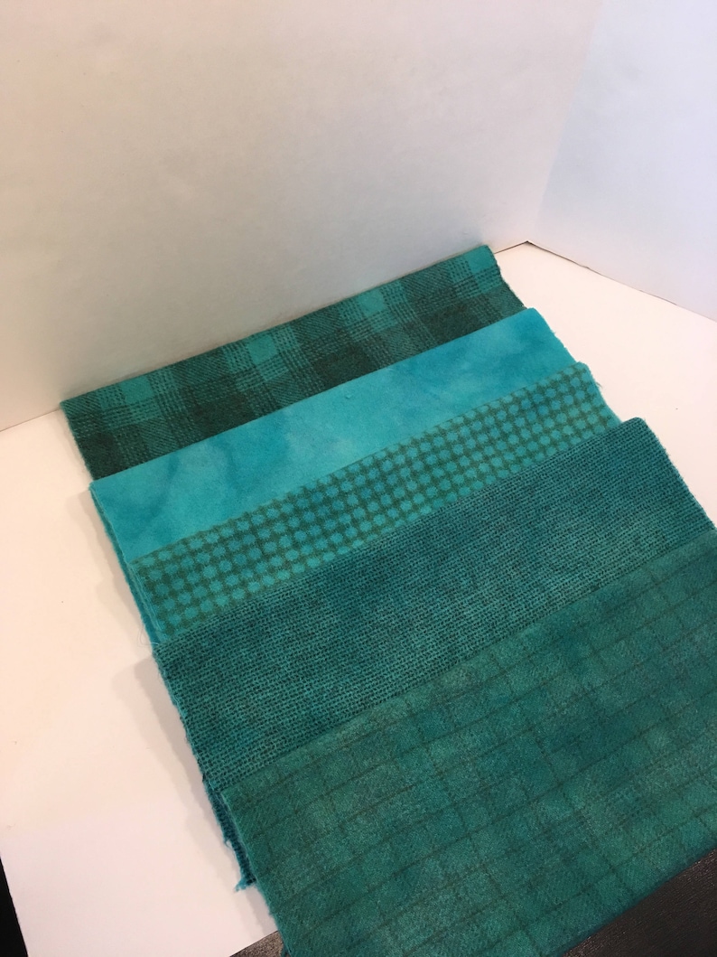 May include: Five different teal fabric swatches with various patterns, including plaid, tie-dye, polka dots, and woven textures.