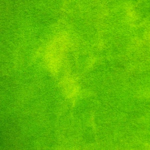 May include: A close-up shot of a vibrant green fabric. The material has a soft, velvety texture with subtle variations in color, creating a textured appearance. The fabric's bright green hue suggests a natural or organic theme.