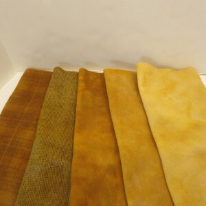 Puede incluir: Muestras de tela en tonos dorados y marrones. Las texturas incluyen un estampado de cuadros, un dise&ntilde;o tejido y un material suave similar al ante. Las muestras se muestran una al lado de la otra, mostrando las variaciones de color.