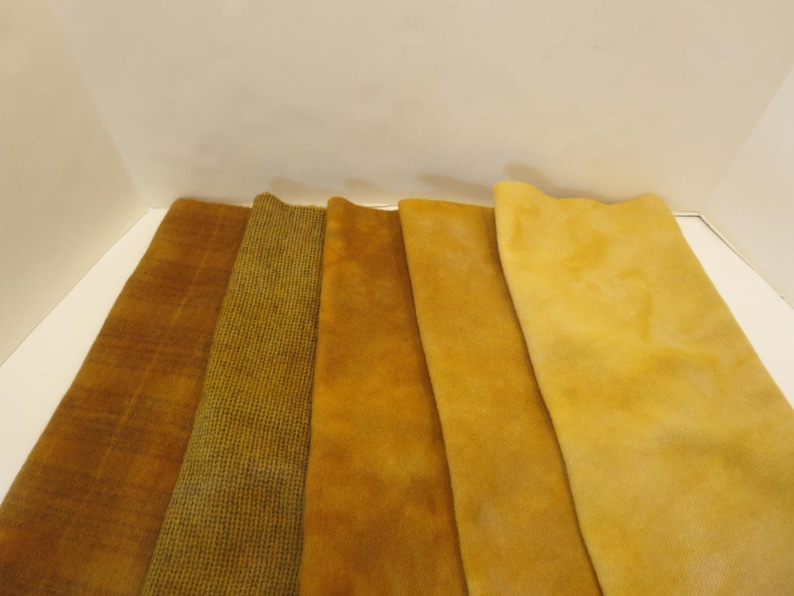 Puede incluir: Muestras de tela en tonos dorados y marrones. Las texturas incluyen un estampado de cuadros, un dise&ntilde;o tejido y un material suave similar al ante. Las muestras se muestran una al lado de la otra, mostrando las variaciones de color.