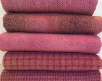 May include: A stack of six pink fabric squares with different patterns. The fabric is soft and textured.