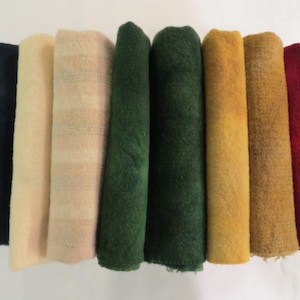 May include: Eight rolls of fabric in various colours, including navy blue, cream, pink, green, mustard yellow, and red.