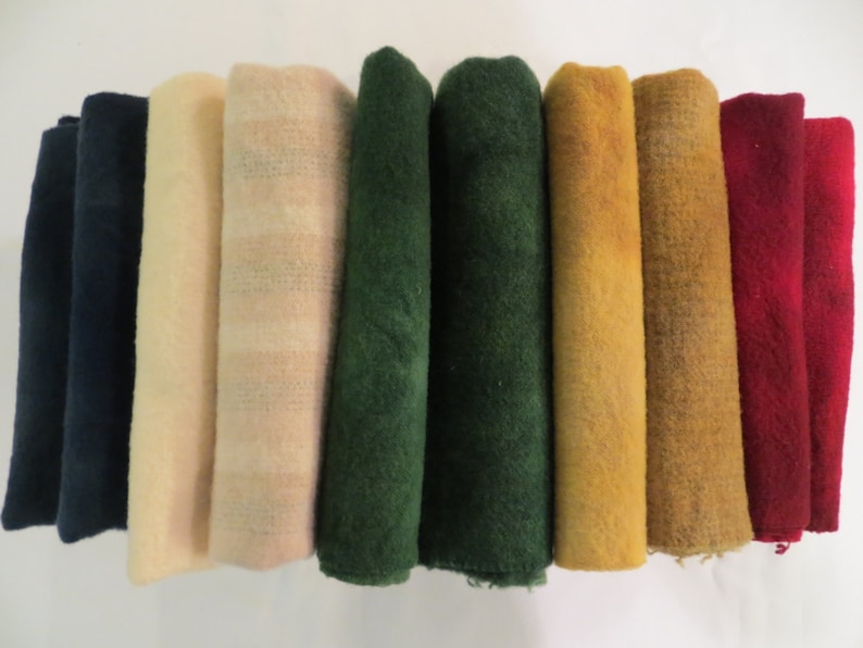 May include: Eight rolls of fabric in various colours, including navy blue, cream, pink, green, mustard yellow, and red.