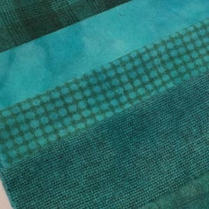 May include: Four different teal fabric swatches with various patterns. The top swatch is a plaid pattern, the second is a solid colour, the third is a small dot pattern, and the bottom is a woven burlap fabric.