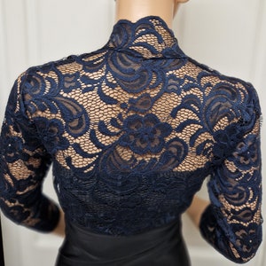 Lace bolero with a slight stretch in a two tone Black and Navy with 3/4 sleeves , Scalloped neckline and down the fronts . Ideal for a special occasion