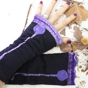 May include: A pair of black fingerless gloves with purple velvet trim and purple fabric roses. The gloves are made of a soft, stretchy fabric.