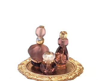 Bandeja de tocador vintage en miniatura para casa de muñecas con frascos de perfume violetas.