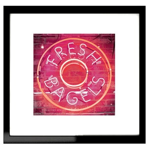 May include: A neon sign in the shape of a bagel with the words "FRESH BAGELS" in white letters on a pink background.