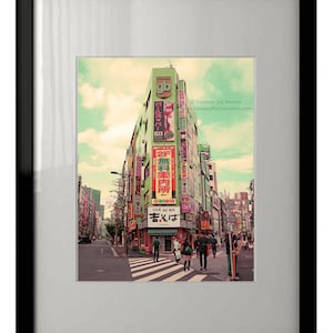 May include: A colourful street scene in Tokyo, Japan, with a tall building featuring many signs and advertisements. The building is green and has a sign that says "gb" in white letters. People are walking on the street in front of the building.