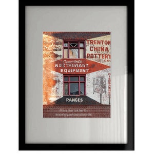 Puede incluir: Impresión enmarcada de un edificio de ladrillo desgastado con letreros descoloridos. El texto incluye "Trenton China Pottery" y "Complete Restaurant Equipment". La imagen presenta dos ventanas y un letrero en forma de flecha.