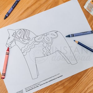 May include: A black and white line drawing of a Dala horse, a traditional Swedish wooden toy horse, on a white sheet of paper. Crayons and pencils are visible on the table.