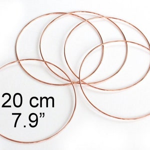 May include: Five copper wire hoops, each measuring 7.9 inches in diameter. The hoops are arranged in a circular pattern, with the largest hoop in the center and the smallest hoop on the outside.