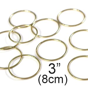 May include: A set of eight gold-colored metal jump rings, each measuring 3 inches (8 cm) in diameter.