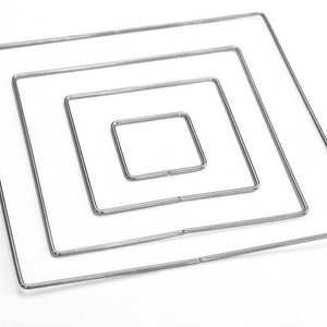May include: Four silver metal hoops, each a different size, are nested inside each other to create a square shape.