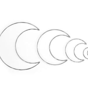 May include: A set of five silver metal crescent moon shapes, arranged in decreasing size from left to right.