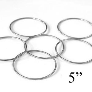 May include: Five silver metal hoops, each measuring 5 inches in diameter.