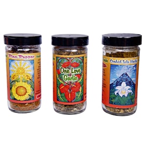 Könnte beinhalten: Drei Glasbehälter mit schwarzen Deckeln, gefüllt mit getrockneten Kräutern und Gewürzen. Die Etiketten auf den Behältern lauten "Plan Pepper", "One Love Garlic" und "Orchid Isle Herbs".