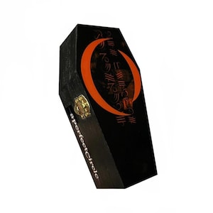May include: Black coffin-shaped box with an orange crescent moon design and stylized text. The box has a gold-colored clasp and the words "a perfect circle" printed vertically on the side.
