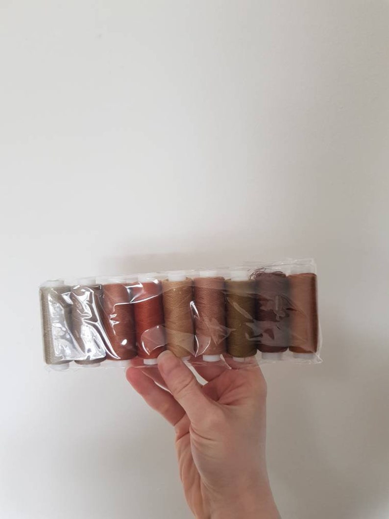 9 spools of polyester thread in different shades of brown