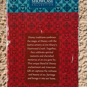 May include: A box featuring the "Walt Disney Showcase Collection" logo. The box has a red and blue geometric pattern with Mickey Mouse icons. Text on the box describes Disney traditions and American folk art.
