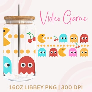 Könnte beinhalten: Ein durchsichtiger Glasbecher mit Holzdeckel und silbernem Strohhalm. Der Becher ist mit einem Pac-Man-Design in Gelb, Blau und Rot verziert. Die Worte "Video Game" sind in Rosa geschrieben.
