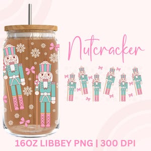 May include: A clear glass Libbey can-shaped glass with a bamboo lid and a silver straw. The glass is decorated with a teal and pink nutcracker design, snowflakes, and pink bows. The word "Nutcracker" is written in pink script.