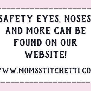 May include: A white sign with black text that reads "SAFETY EYES, NOSES, AND MORE CAN BE FOUND ON OUR WEBSITE! WWW.MOMSSTITCHETTI.COM".
