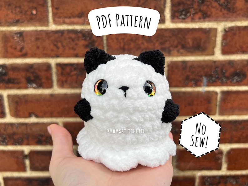 May include: A white and black crocheted plush ghost with iridescent eyes. The ghost is sitting on a brick wall. The text 'PDF PATTERN' is above the ghost, and the text 'NO SEW!' is below the ghost. The text '@MDMSStitchetti' is on the ghost's chest.