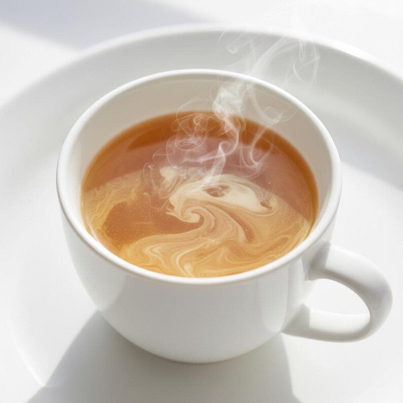 May include: A white ceramic mug filled with a warm, amber-colored beverage, possibly tea or coffee, with a swirl of cream. Steam rises from the liquid, creating a sense of warmth. The mug sits on a white plate, with soft shadows.