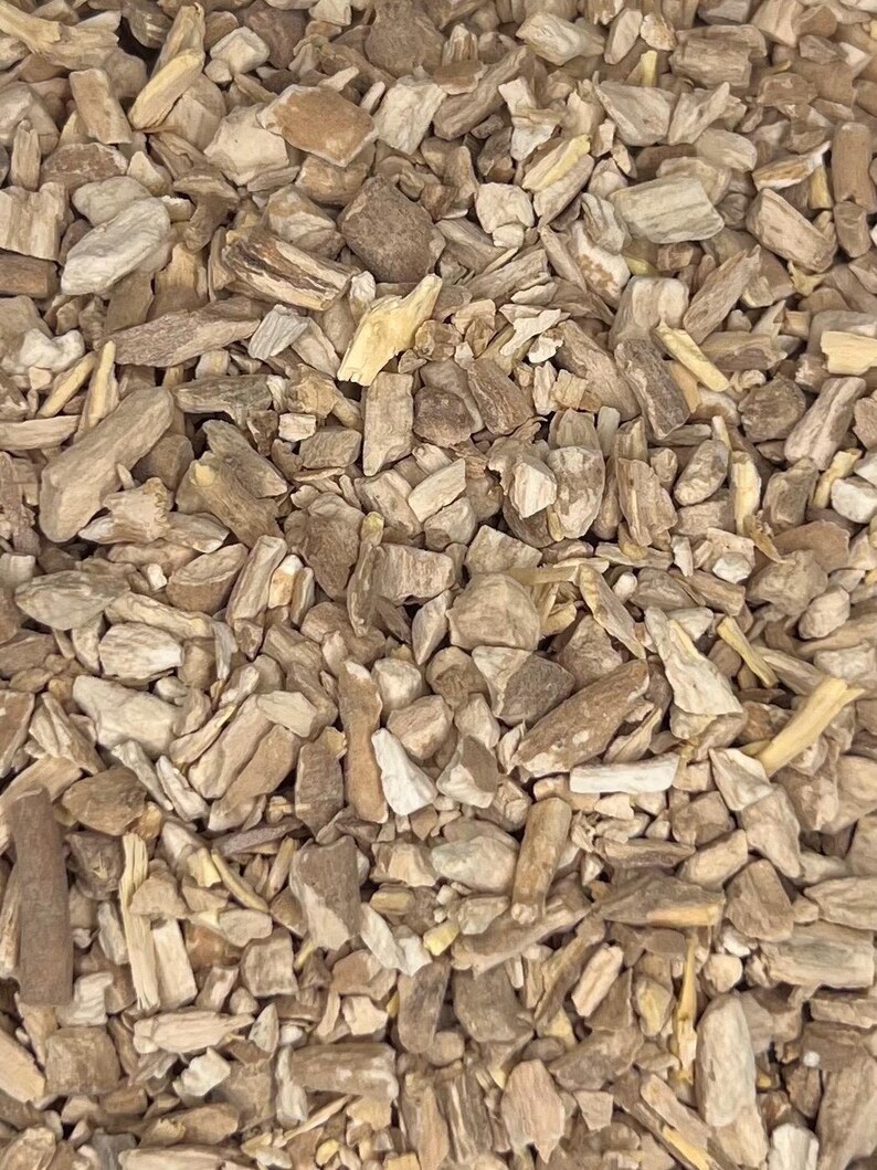May include: A close-up shot of a collection of chopped wood pieces in shades of brown and beige. The pieces vary in size and shape, with a rough, natural texture. Some pieces resemble small chunks, while others are more like splinters, creating a textured surface.