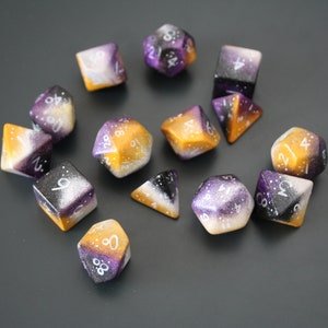 May include: A set of 12-sided dice with a galaxy-inspired design. The dice are painted in shades of purple, black, and gold with white glitter and white numbers.