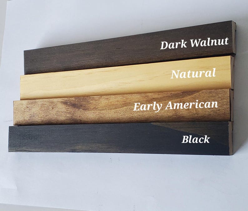 Puede incluir: Primer plano de cuatro tablas de madera, cada una te&ntilde;ida de un color diferente: nogal oscuro, natural, early american y negro. Los nombres de los colores est&aacute;n escritos en texto blanco en cada tabla.