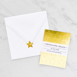 May include: A white envelope with a gold star seal beside a gold foil card. The card reads "ENVELOPE SEALS" and "36 star seals". The card has a star pattern and the text "Seal your snail mail with love."