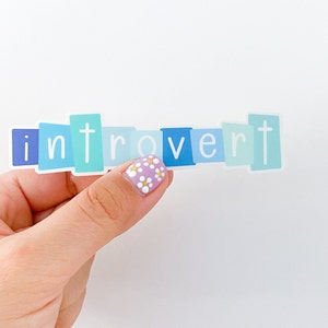 May include: A sticker with the word "introvert" spelled out in blue, green, and white letters on a white background.