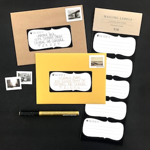 May include: A pack of 15 blank mailing labels with a black border and a heart design. The labels are on a white background and are packaged in a clear plastic sleeve. The text "MAILING LABELS" and "SIB" are printed on the packaging.