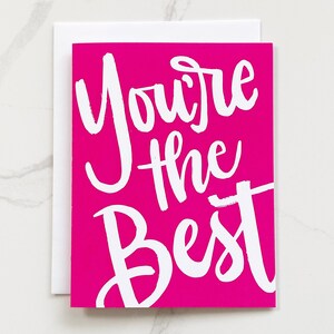 May include: A pink card with white lettering that says "You're the Best".