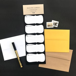 May include: A set of five white mailing labels with black borders and the text "Please deliver to" on each label. The labels are attached to a black card with the text "Mailing Labels" and "&pound;1B".