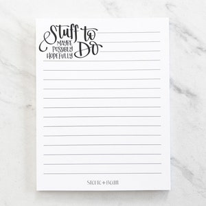 Peut inclure: Bloc-notes blanc avec des lignes noires et le texte "Stuff to Do Maybe Possibly Hopefully" en haut. Le bas du bloc-notes porte le texte "Siene + Bean".