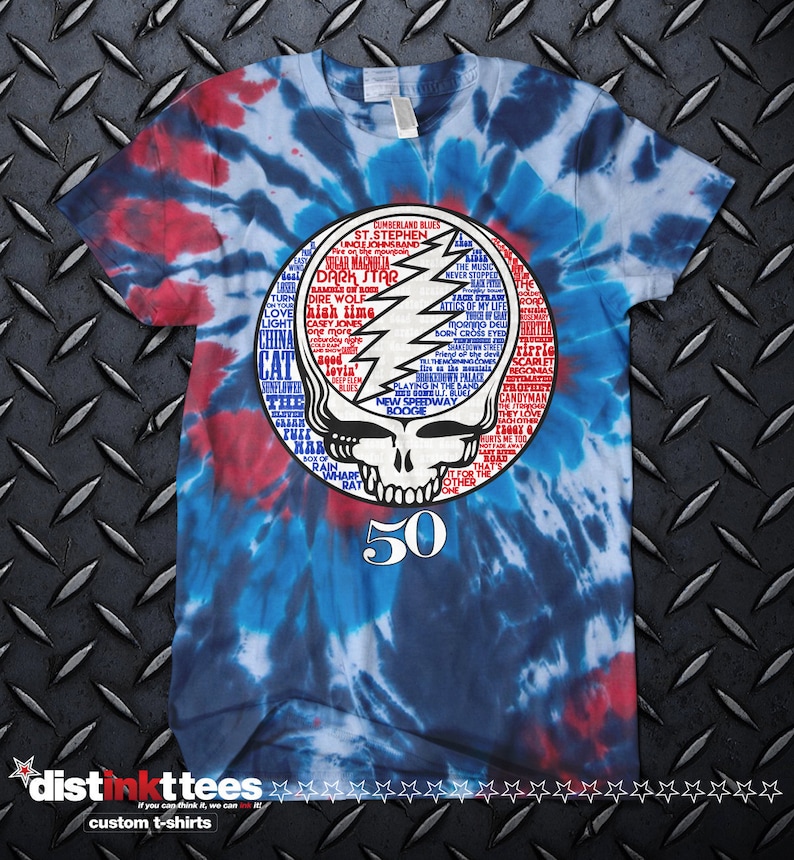 May include: A tie-dye t-shirt with a blue, red and white swirl pattern. The shirt features a graphic of the Grateful Dead's iconic skull and lightning bolt logo surrounded by a circle of song titles. The number 50 is printed below the logo.