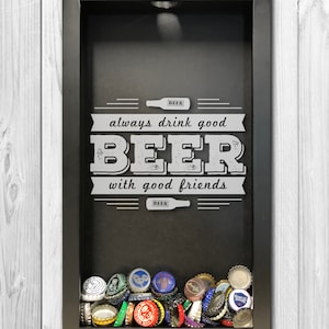 May include: A black shadow box with the words "always drink good BEER with good friends" in white. The bottom of the box is filled with colorful beer bottle caps. A decorative piece for a bar or man cave.